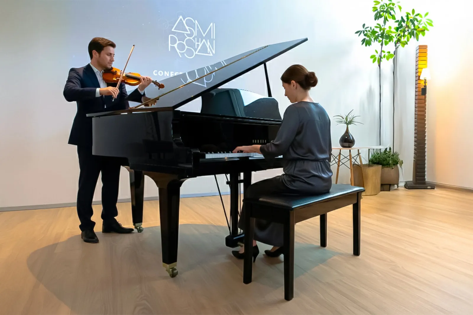 a man and woman playing a piano and violin