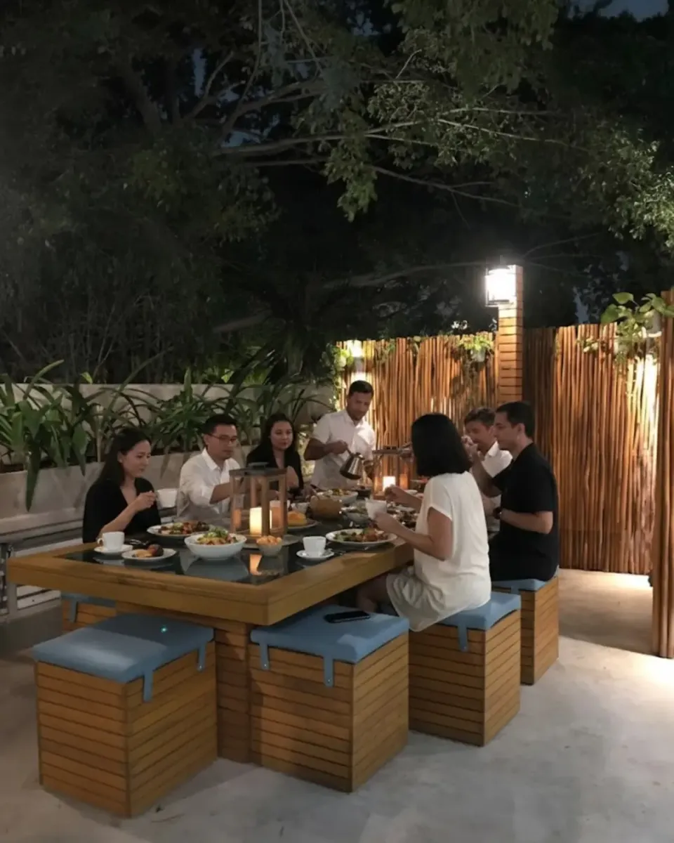a group of people sitting at a table with food
